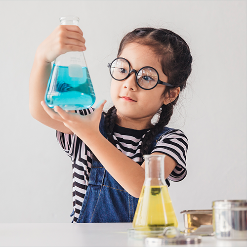 Niña haciendo experimentos con matraces